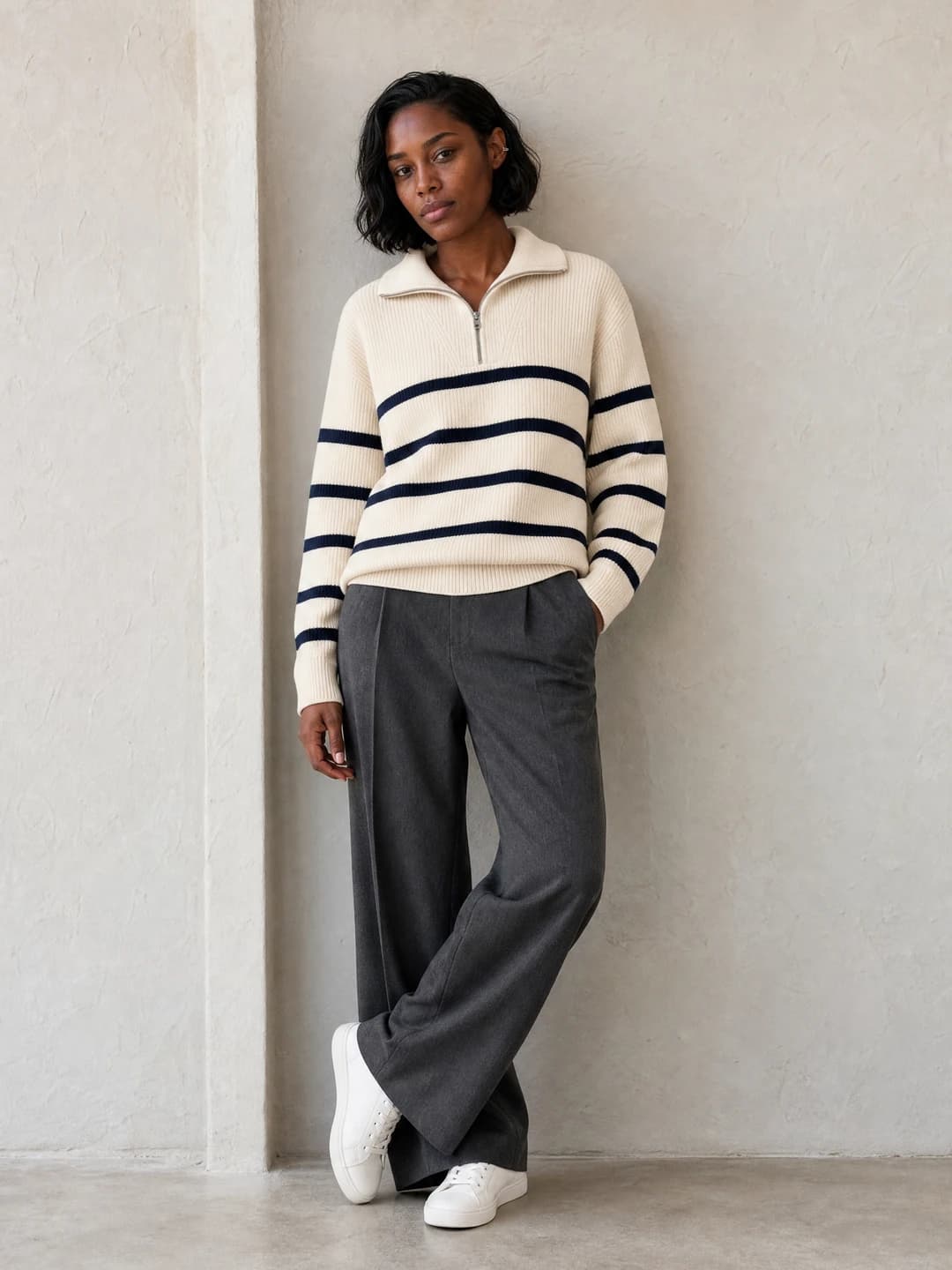 Adult virtual apparel model wearing a cream-and-navy striped half-zip sweater and charcoal trousers