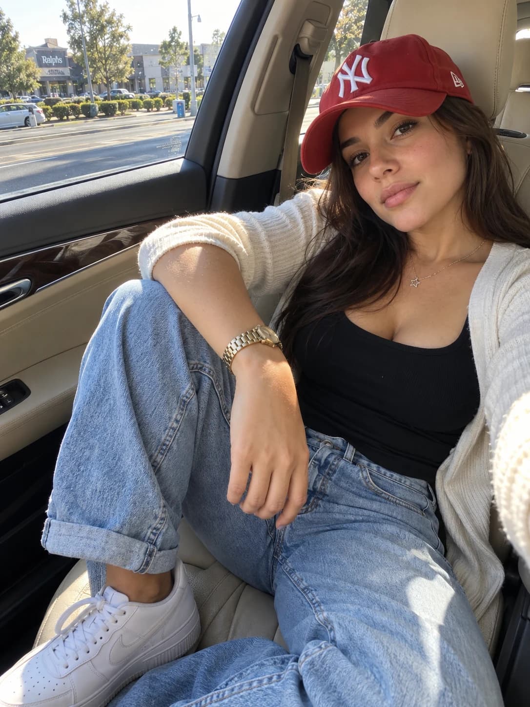 Virtual creator styling a red baseball cap with a cardigan and blue jeans in a parked car