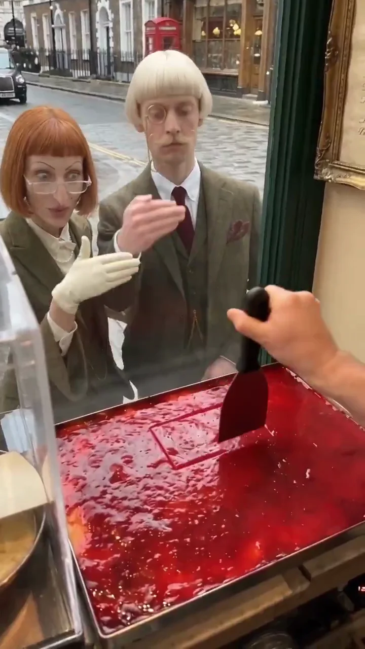 Archibald source video at seven seconds: the recurring pair gesture while a cake portion is cut