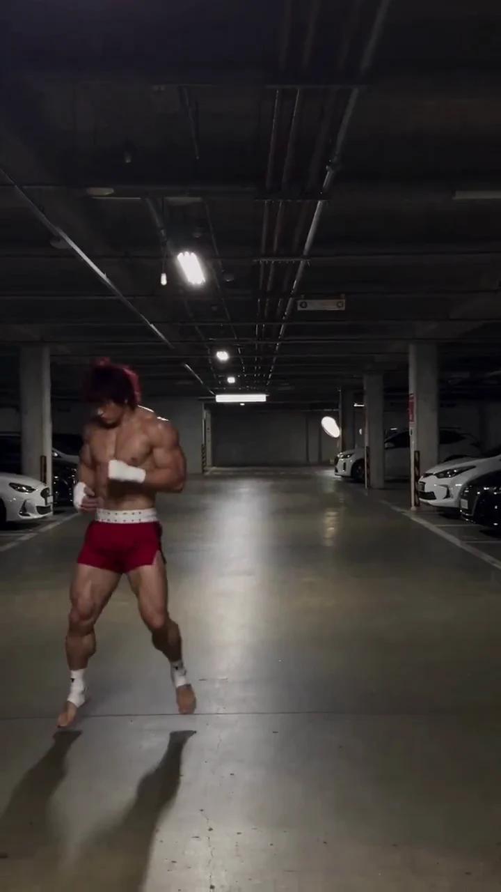 Actual frame at 1 seconds of the Baki video shared on X, used to inspect a training pose and limb placement in a parking garage.