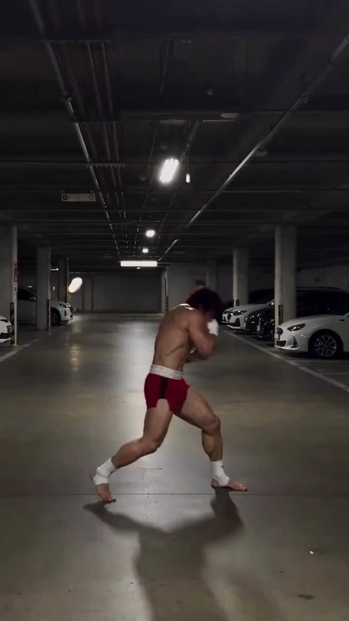 Actual frame at 9 seconds of the Baki video shared on X, used to inspect a training pose and limb placement in a parking garage.