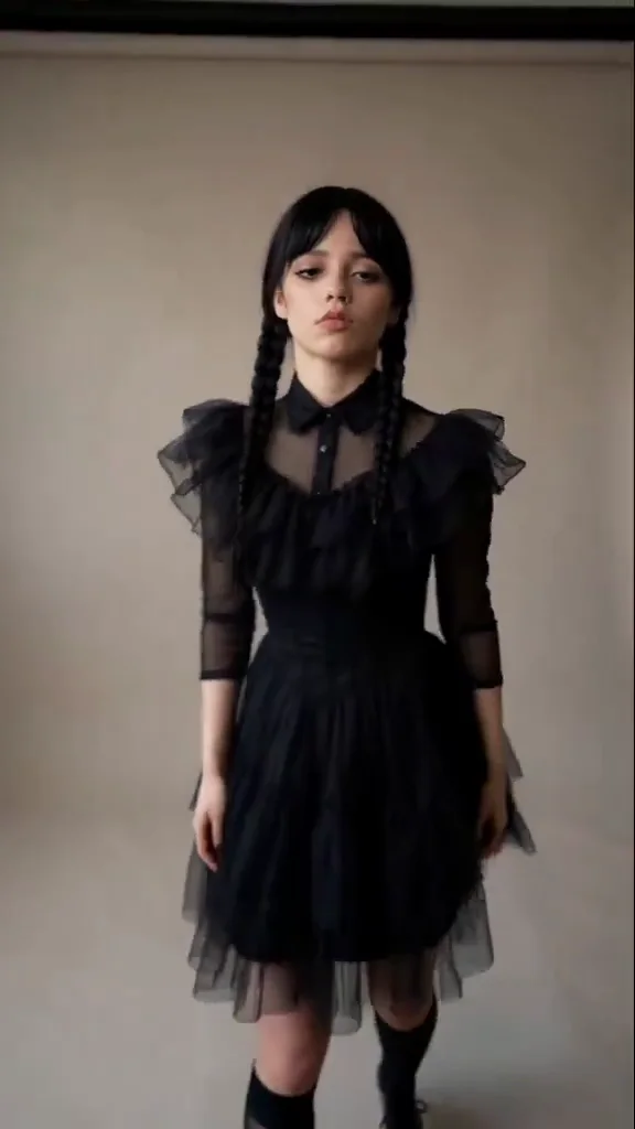 Friday Adams source dance at 0.5 seconds, a braided figure in a black ruffled dress approaching the camera