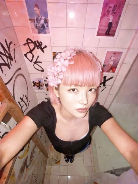 imma with a pink bob haircut in a tiled fashion installation