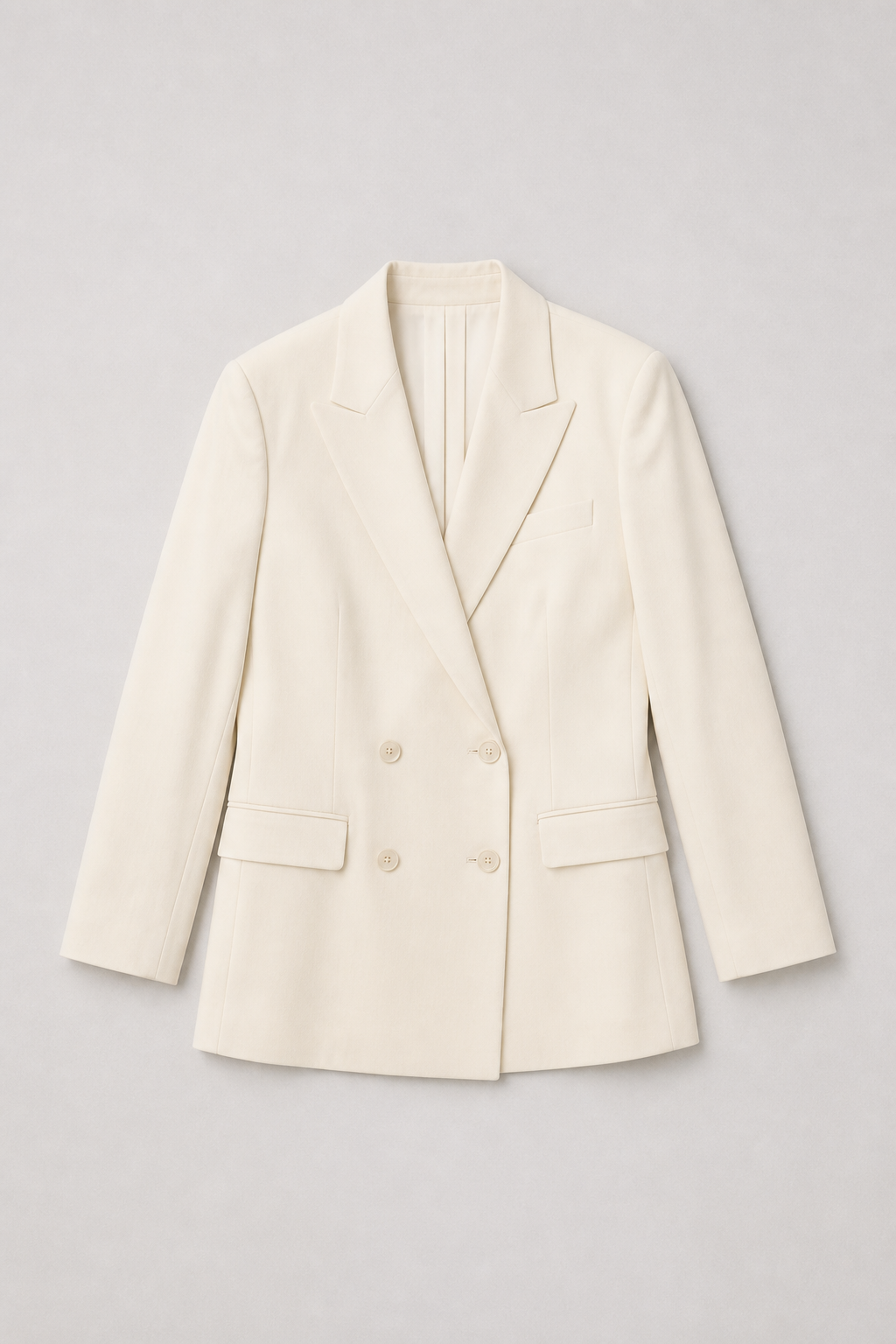 Fictional unbranded ivory double-breasted blazer flat lay.